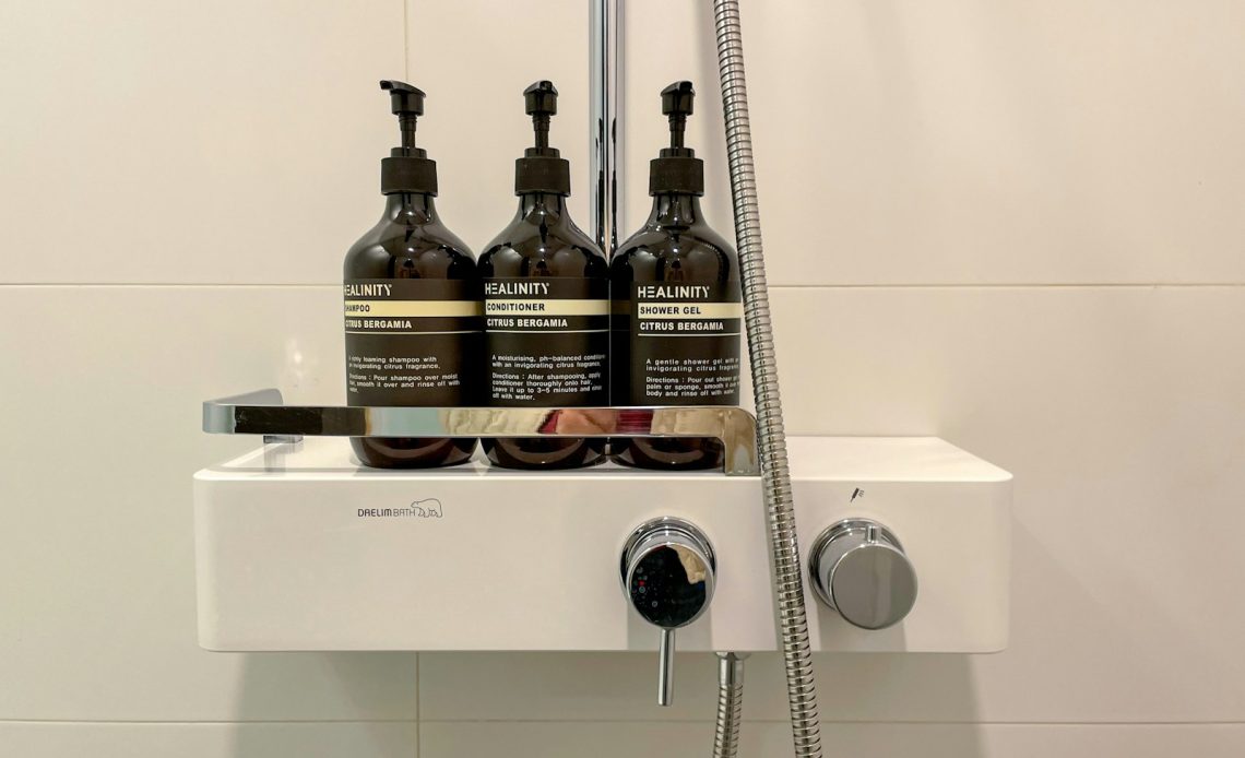 three bottles of shampoo sitting on top of a sink