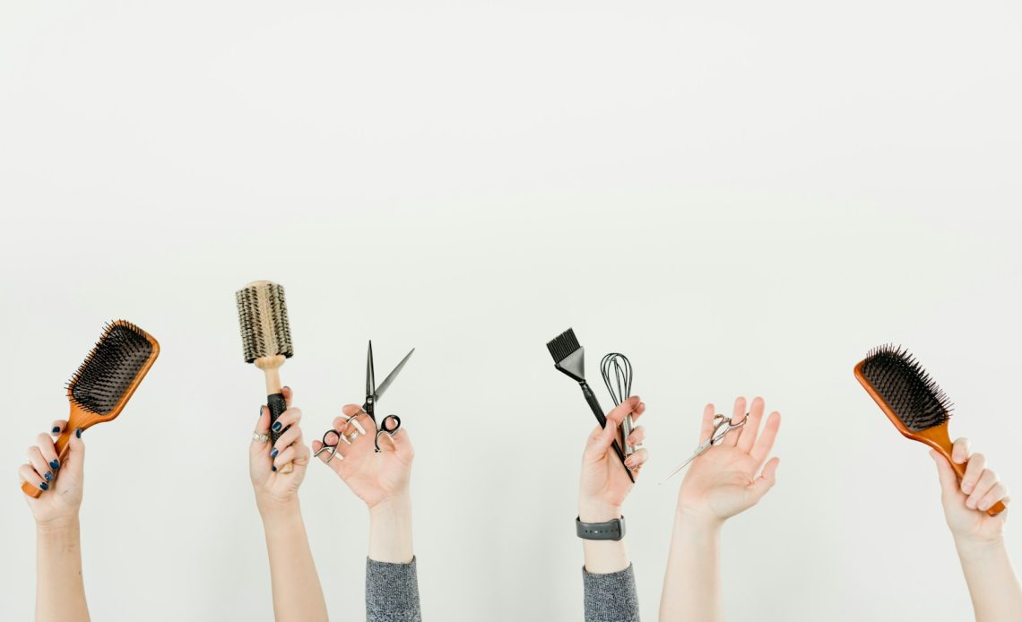 person holding silver and black hair brush