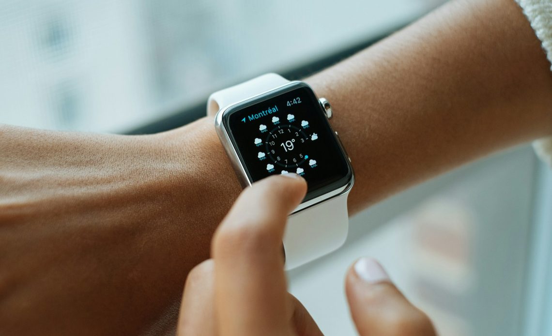 person wearing silver aluminium case Apple Watch with white Sports Band
