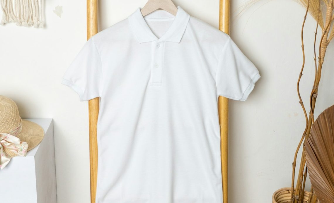 a white polo shirt hanging on a clothes rack