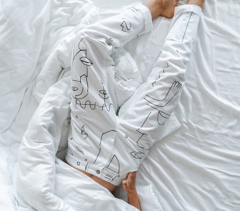 person in white robe holding white textile