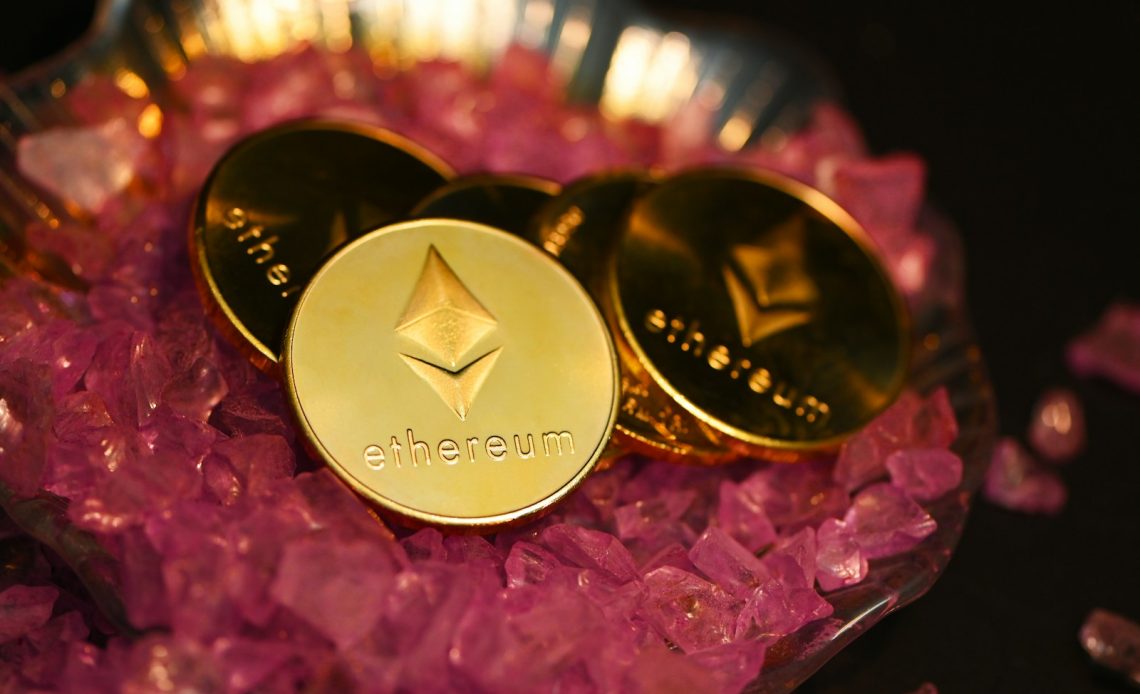 two gold coin sitting on top of a pile of pink crystals