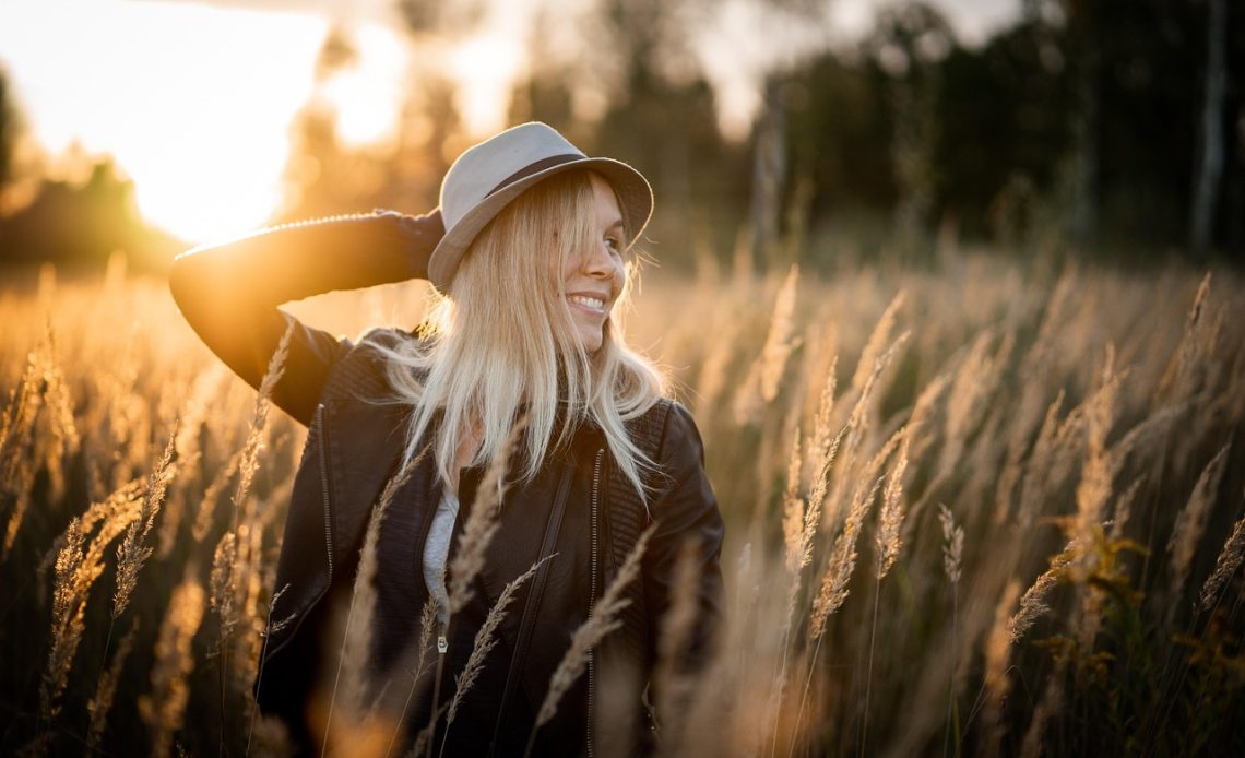 Vrouw die zonnebrand aanbrengt op haar gezicht op een zonnige zomerdag