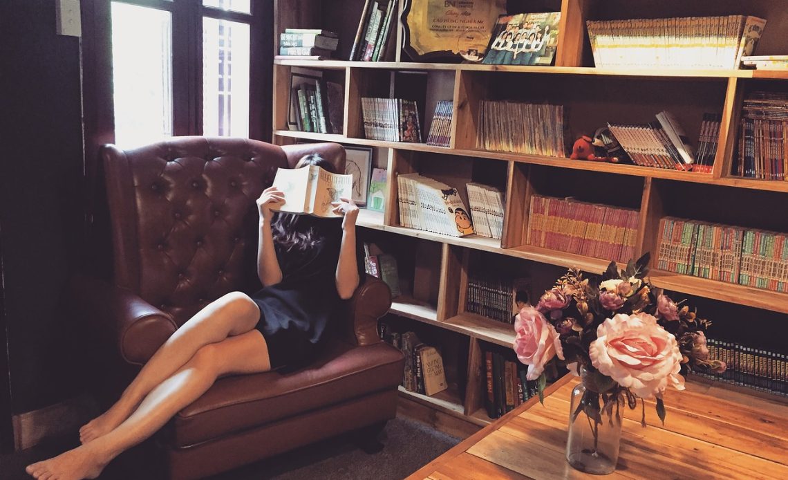 Vrouw die een boek leest op de bank