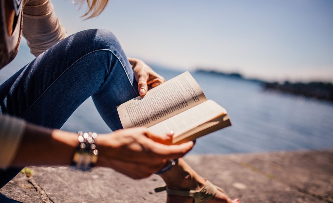 Jonge vrouw die een boek leest in een rustige kamer, mogelijk naast een wieg